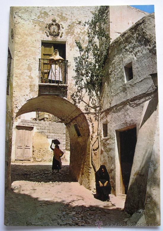 Mujeres tapadas junto a un arco del Mojácar histórico